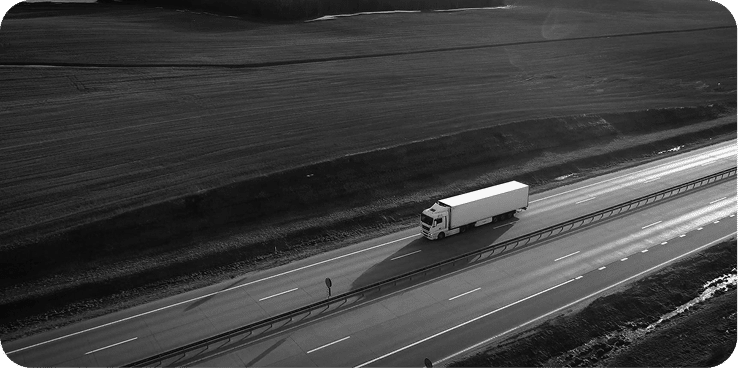 Commercial truck driving on highway through rural landscape